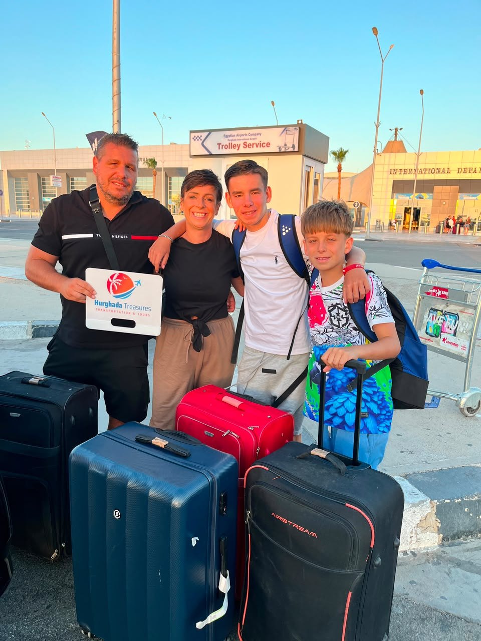 Family welcomed with the Hurghada Treasures sign at Hurghada Airport