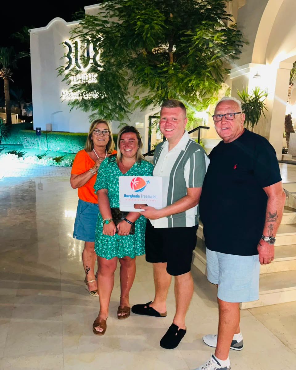 Guests outside their Hurghada hotel at night with the Hurghada Treasures sign
