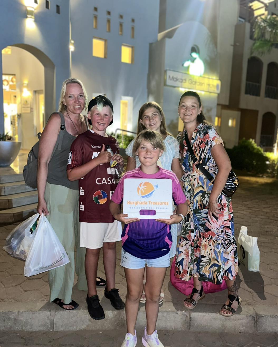 Family with children holding the Hurghada Treasures sign at Makadi Garden Hotel