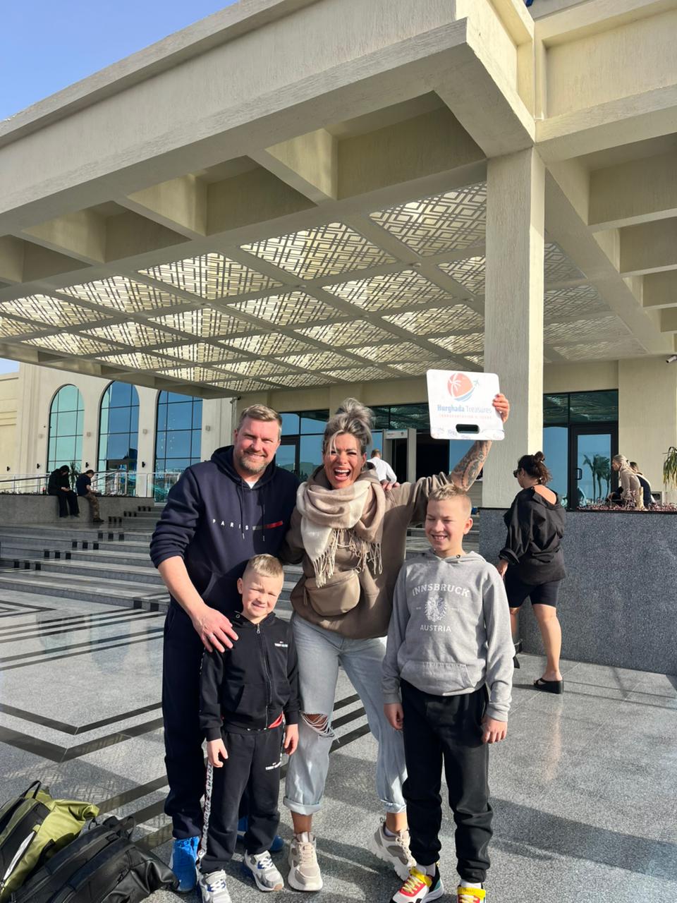 Family with the Hurghada Treasures sign after their private transfer to Albatros Makadi Bay